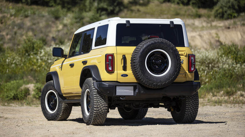 Ford Bronco Heritage Edition rear 3/4 view parked in front of vegetation