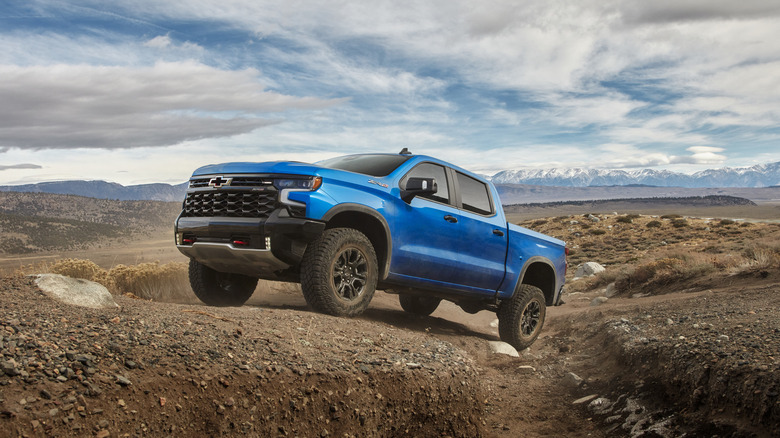 The 2024 Chevrolet Silverado ZR2 in blue off-roading, front 3/4 view