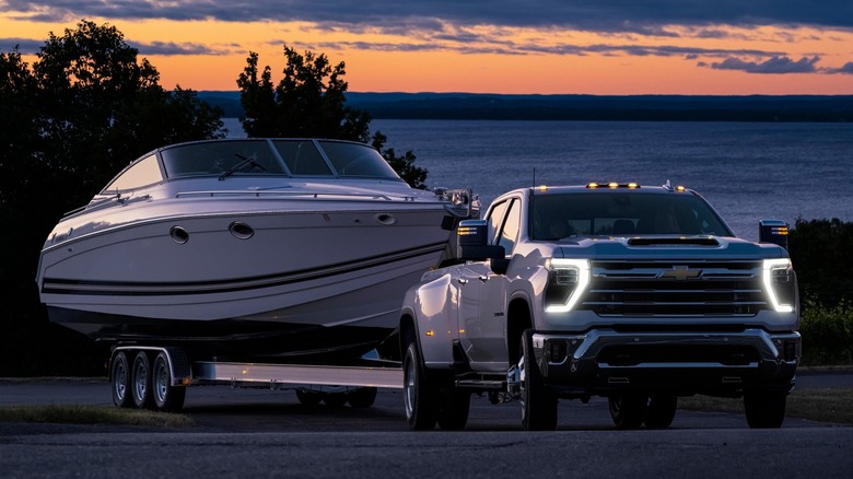 A 2024 Silverado 3500HD in white, towing a speedboat