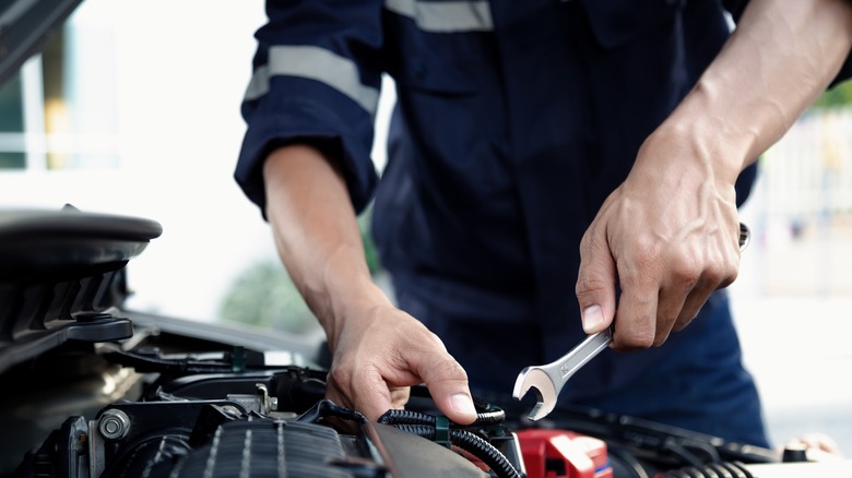 Mechanic working on vehicle in shop