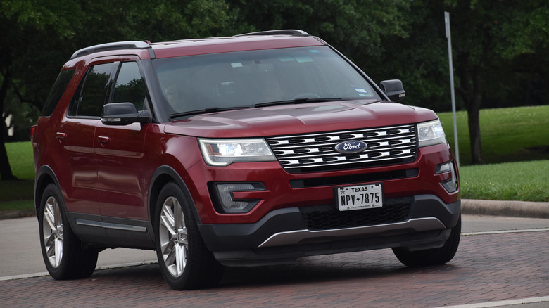 Red Ford Explorer driving down road