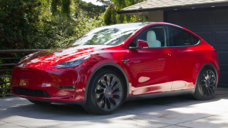 A red Tesla Model Y in a driveway