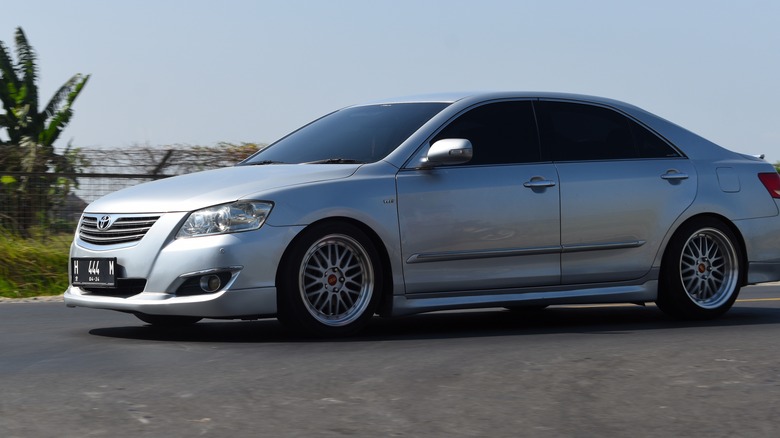 Toyota Camry driving down street