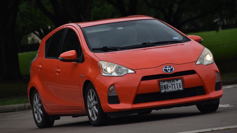 Reddish orange Prius driving