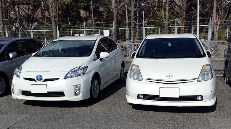 Two white Toyota Priuses in a parking lot