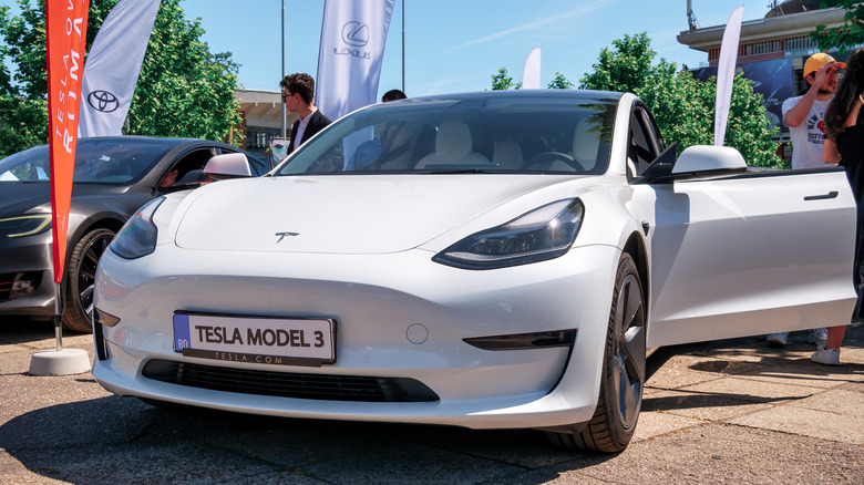 Close up shot of white Tesla model 3 with opened doors