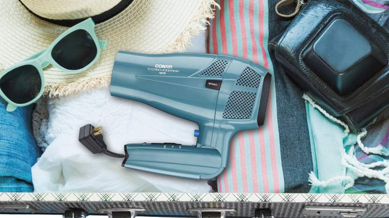 A Conair hair dryer in a dresser drawer with accessories