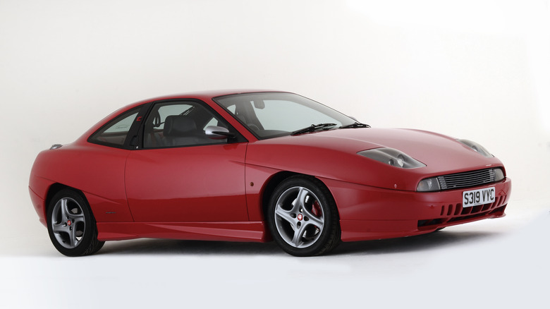 A red Fiat Coupe in a studio, front 3/4 view