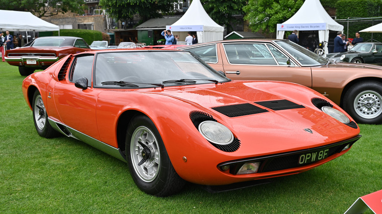 The Lamborghini Miura in orange at a car show, front 3/4 view