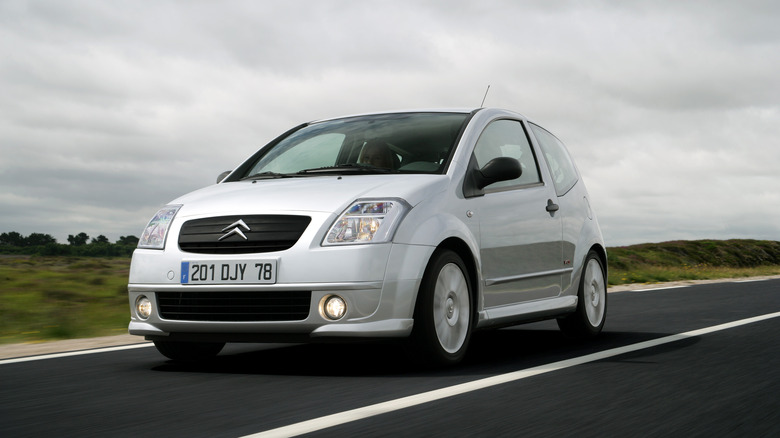 The Citroen C2 in silver driving, front 3/4 view