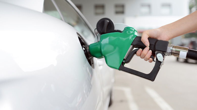 Person refueling with diesel at gas station