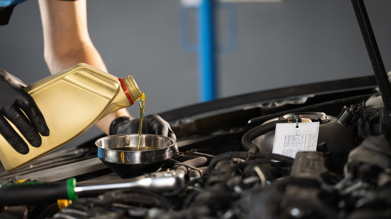 Man pouring oil into engine