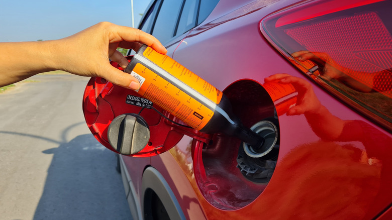 Driver putting an additive into fuel tank