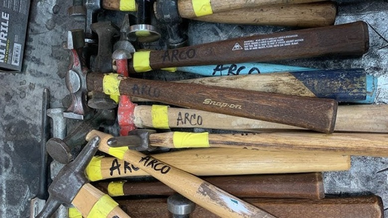 YouTube screenshot of a pile of wooden-handled hammers