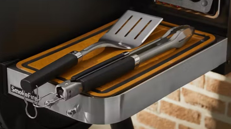 Weber two Piece Stainless Steel Grill Tool Set sitting next to grill