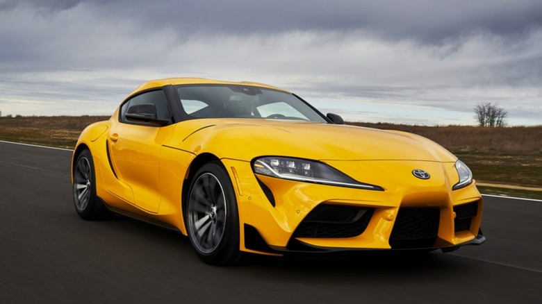 Yellow Toyota Supra on road