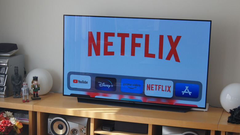 A TV with Netflix running on it kept on a wooden surface