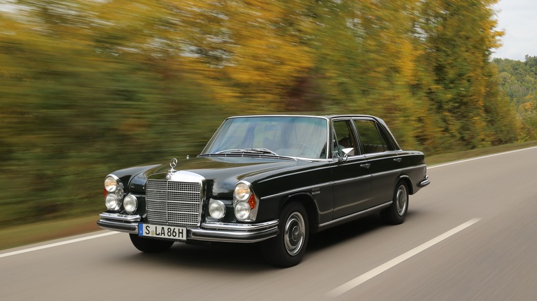 Black Mercedes-Benz 300 SEL 6.3 driving at speed