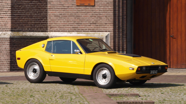 Yellow Saab Sonett III parked in front of a brick wall