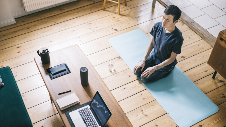 man doing yoga at home with help from a smart speaker