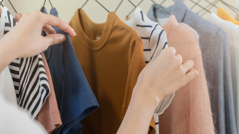 hands browsing through a closet