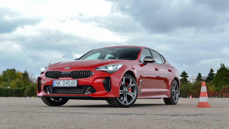 A Kia Stinger GT in red on a slalom course, front 3/4 view