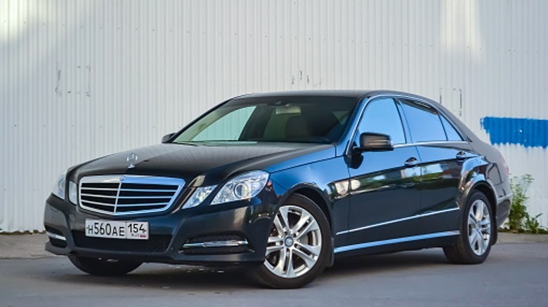 black Mercedez-Benz sedan in front of a white wall