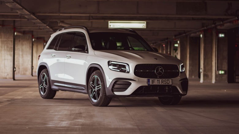 a white Mercedes-Benz SUV in a parking complex