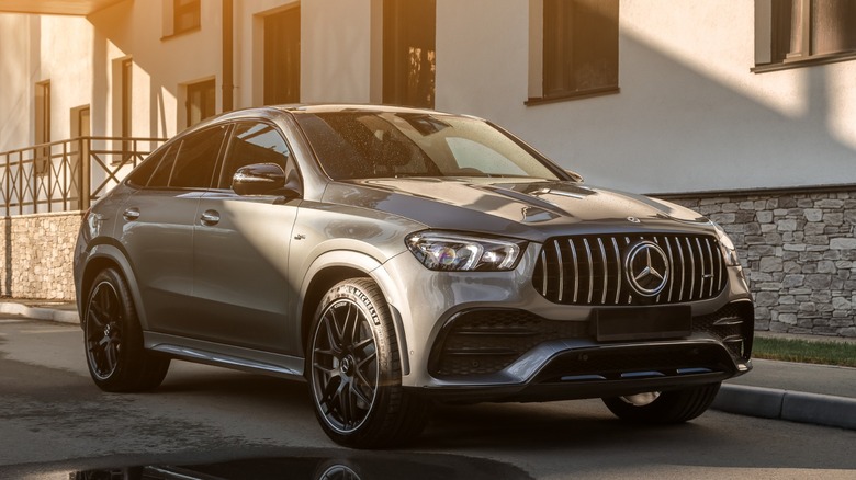 a grey mercedes SUV on the side of a road