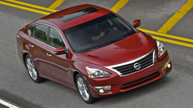 Red 2013 Nissan Altima driving