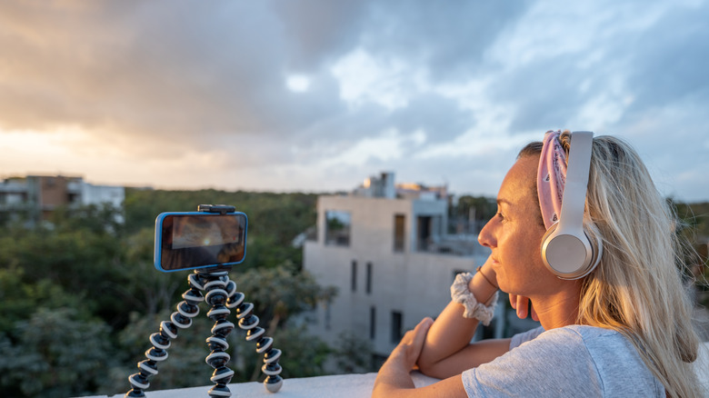 woman watching phone on stand