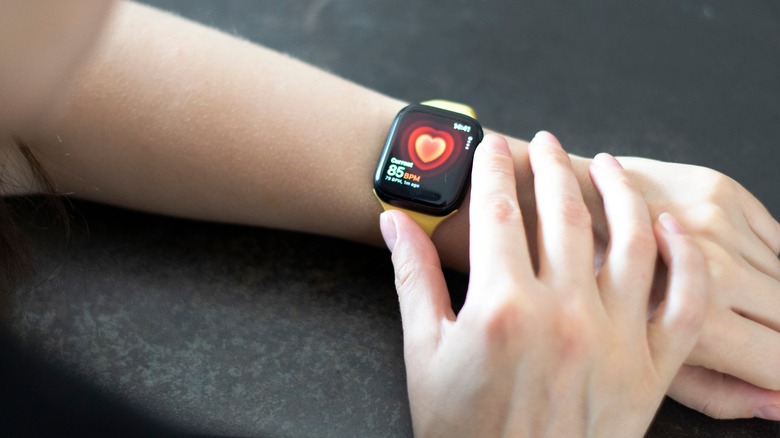 Woman hand with Apple Watch Series 8 measuring heart rate.