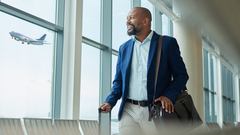 A happy business traveler at an airport.