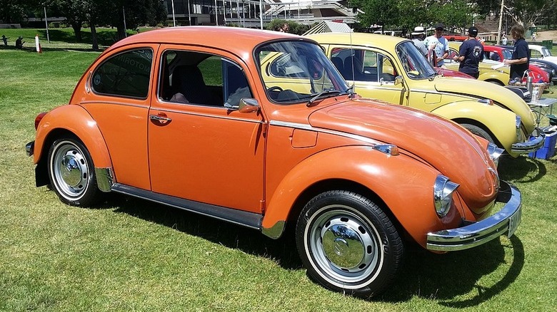 Orange Volkswagen Super Beetle at a car show