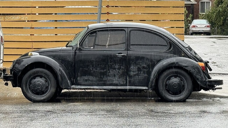 Black Volkswagen Super Beetle in the rain