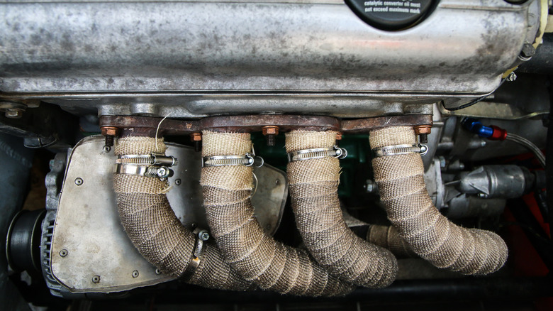 Exhaust wraps around the exhaust manifold of a car engine