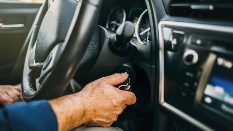 A man starting the engine of the car