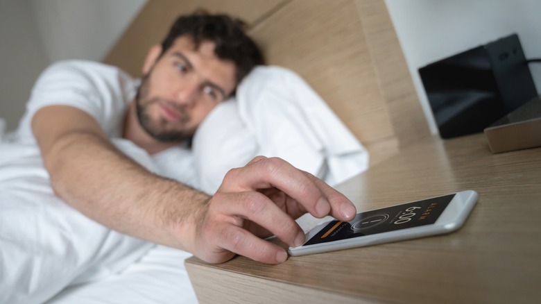 Woman setting an alarm on a smartphone