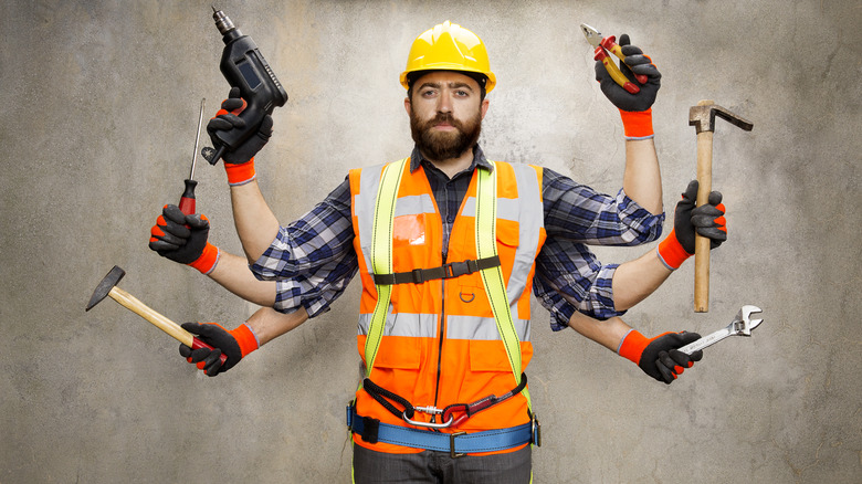 white guy in orange vest with a yellow hard hat and six arms holding tools