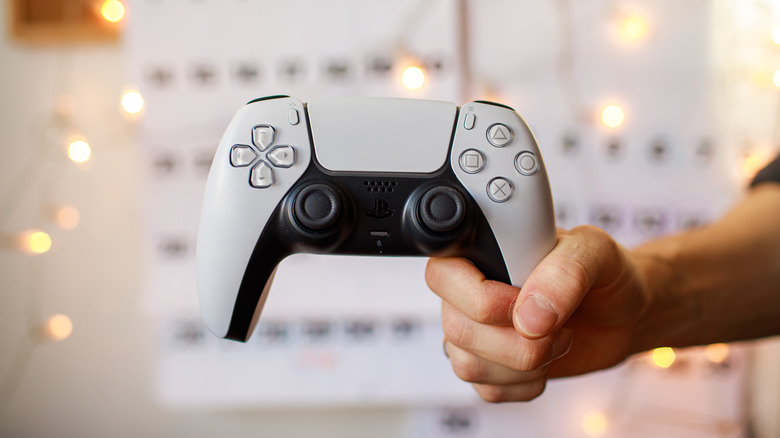 A person holding a PS5 controller