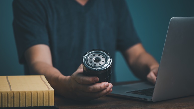 A man holding an oil filter