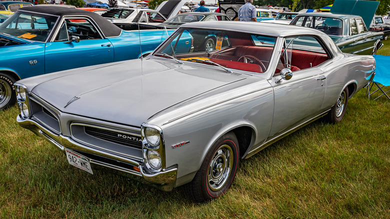 A gray Pontiac Tempest parked in the grass