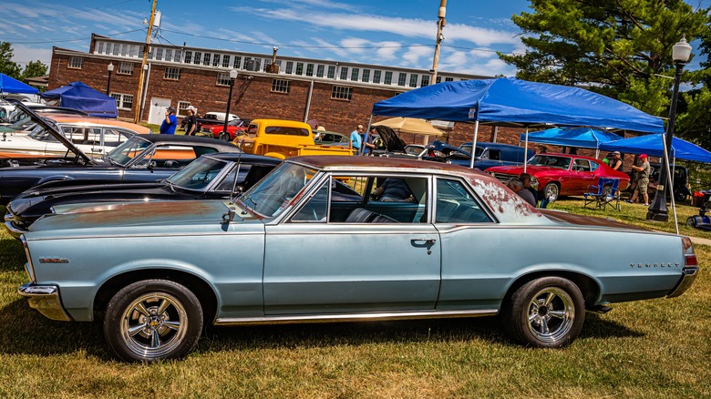 A slightly beat up Pontiac Tempest at an auto show