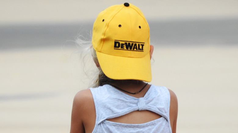 girl on vacation wearing a DeWalt hat