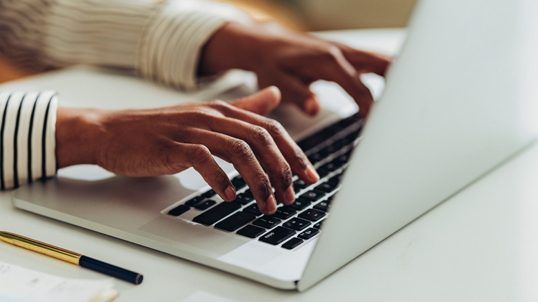 Woman typing at Mac