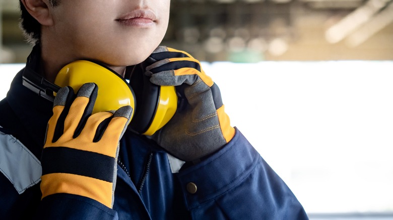 Woman holding ear defenders