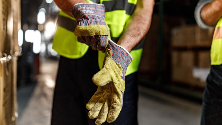 Worker putting on protective gloves