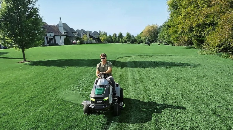 man mowing lawn on Ego lawn tractor