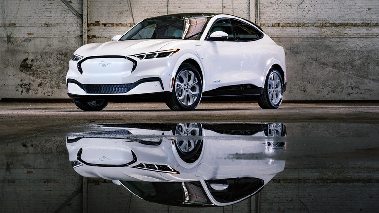 White 2022 Ford Mustang Mach-E over a puddle of water with its reflection