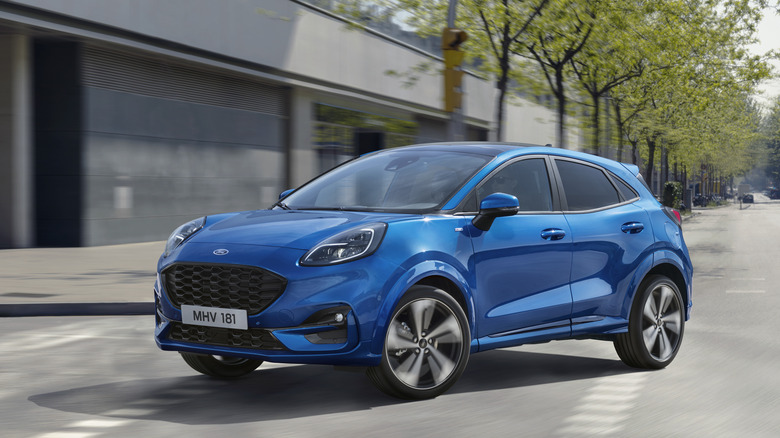 2024 Ford Puma cornering at speed in urban settings with blurred background